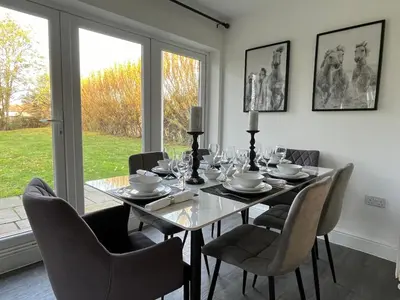 a dining room with a glass table and chairs at Cottage Stay in Hingham in Hingham
