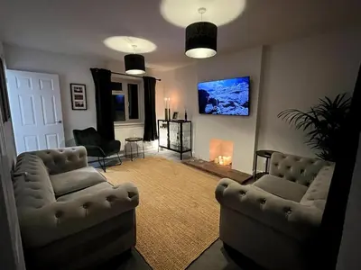 a living room with two couches and a flat screen tv at Cottage Stay in Hingham in Hingham