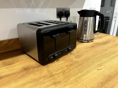 a toaster oven sitting on a counter next to a coffee pot at Cottage Stay in Hingham in Hingham