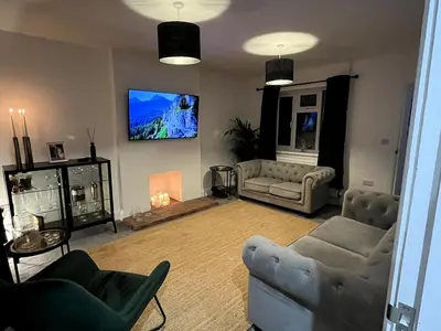a living room with two couches and a flat screen tv at Cottage Stay in Hingham in Hingham