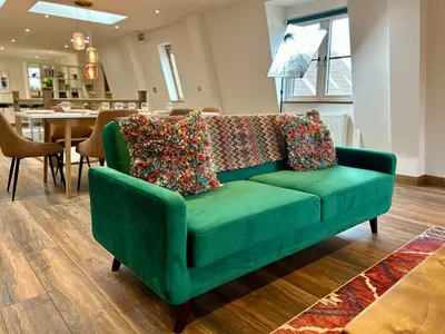 a green couch with pillows on it in a living room at Luxury Retreat with Spa Access - Sleeps 6 in Peldon