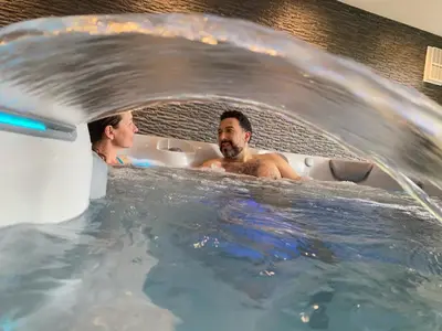 two men are in a bathtub with water at Luxury Retreat with Spa Access - Sleeps 6 in Peldon