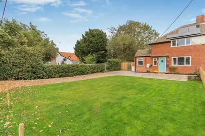 an empty yard in front of a brick house at 2 Bed in Knodishall oc-s33543 in Friston