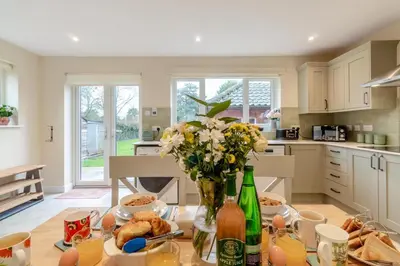a kitchen with a table with flowers and drinks at 2 Bed in Knodishall oc-s33543 in Friston