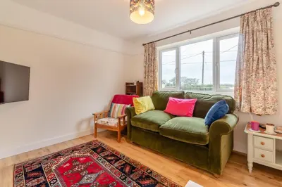 a living room with a green couch and a window at 2 Bed in Knodishall oc-s33543 in Friston