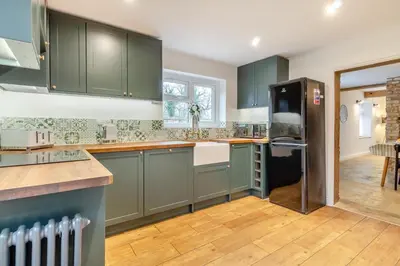 a kitchen with green cabinets and a black refrigerator at 2 Bed in Fincham oc-t33561 in Fincham