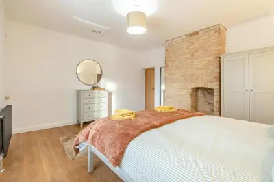 a bedroom with a white bed and a brick wall at 2 Bed in Fincham oc-t33561 in Fincham