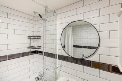 a white tiled bathroom with a mirror and a sink at 2 Bed in Fincham oc-t33561 in Fincham