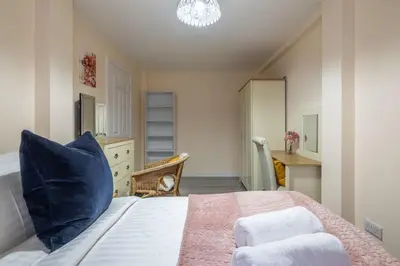 a bedroom with a large bed with a blue pillow at Newly refurbed 3Bed Annexe - With Parking! in Albury