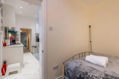 a bedroom with a bed and a kitchen at Newly refurbed 3Bed Annexe - With Parking! in Albury
