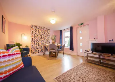 a living room with a table and a dining room at Stylish central location 3 bedroom house in Ely