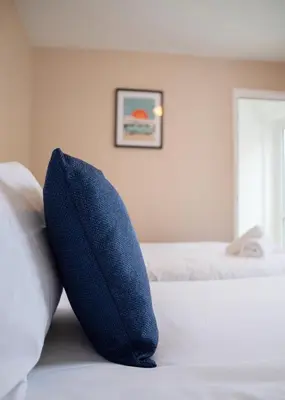 a blue pillow sitting on top of a bed at Stylish central location 3 bedroom house in Ely