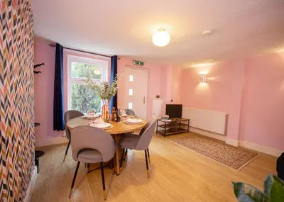 a dining room with a table and chairs and a window at Stylish central location 3 bedroom house in Ely
