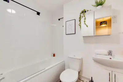 a white bathroom with a toilet and a sink at Pass the Keys Ground Floor Apartment with Free Parking in Cambridge