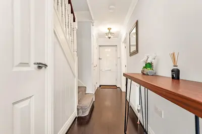 a hallway with white walls and a wooden counter top at Chic 3Bed House & Garden Near Shelford High Street in Trumpington