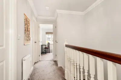 a hallway with white walls and a stairway at Chic 3Bed House & Garden Near Shelford High Street in Trumpington