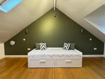 a bed in a room with a green wall at 4 bed Townhouse in Central Bury St Edmunds in Bury Saint Edmunds