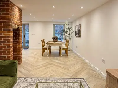 a dining room with a table and chairs and a brick wall at 4 bed Townhouse in Central Bury St Edmunds in Bury Saint Edmunds
