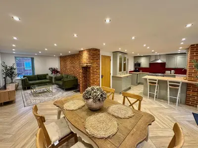 a large living room with a table and a kitchen at 4 bed Townhouse in Central Bury St Edmunds in Bury Saint Edmunds