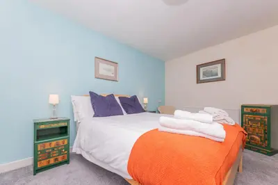 a bedroom with a bed with towels on it at Top Step Cottage in Aldeburgh