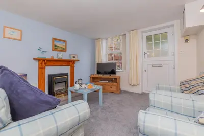 a living room with two couches and a fireplace at Top Step Cottage in Aldeburgh
