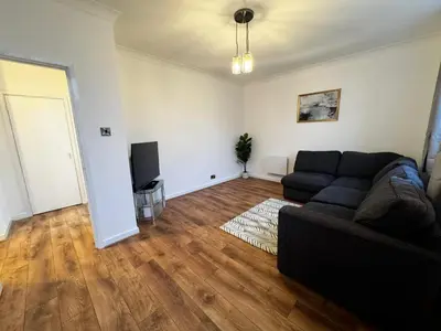 a living room with a couch and a television at Cosy Apartment in Chelmsford City, Free WiFi & Free Parking - Durrant Apartment by Stays Accommodation - Long Stays Welcome in Chelmsford