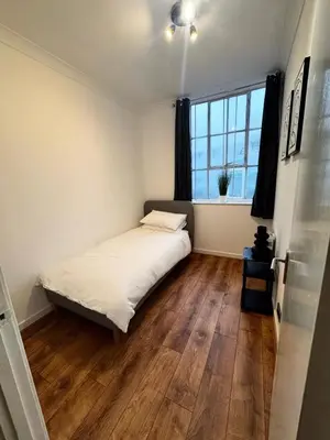 a small bedroom with a bed and a window at Cosy Apartment in Chelmsford City, Free WiFi & Free Parking - Durrant Apartment by Stays Accommodation - Long Stays Welcome in Chelmsford