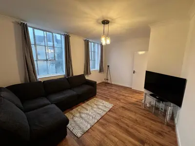 a living room with a couch and a flat screen tv at Cosy Apartment in Chelmsford City, Free WiFi & Free Parking - Durrant Apartment by Stays Accommodation - Long Stays Welcome in Chelmsford