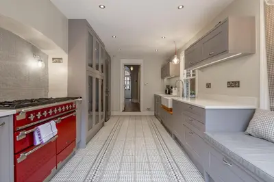 a kitchen with red and white cabinets and a stove at Stylish Victorian Home Nr Cambridge Station in Cambridge