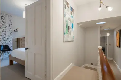 a bedroom with a white door and a bed at Stylish Victorian Home Nr Cambridge Station in Cambridge