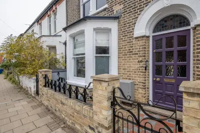 a house with a blue door and a fence at Stylish Victorian Home Nr Cambridge Station in Cambridge