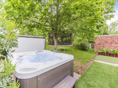 a hot tub in a yard with a tree at Willow Loft - Uk49479 in Bulmer