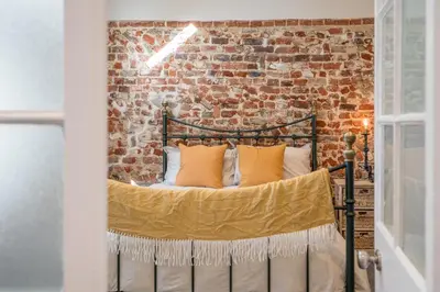 a bed in a room with a brick wall at Suffolk House, Saxmundham in Saxmundham