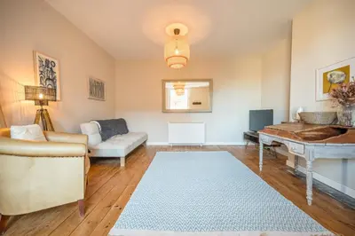 a living room with a couch and a table at Suffolk House, Saxmundham in Saxmundham