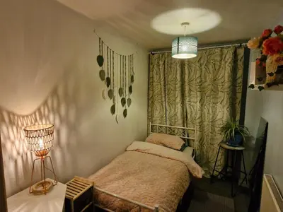 a small bedroom with a bed and a lamp at The Green Box in Great Clacton