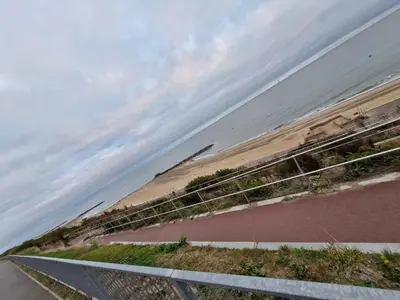 a view of a beach with a fence and the ocean at The Green Box in Great Clacton