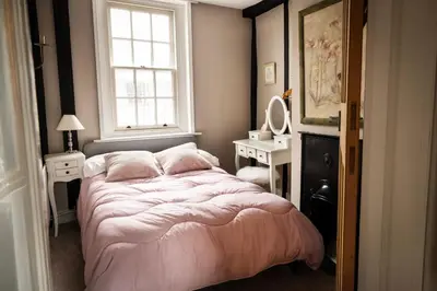a bedroom with a large bed and a window at Old Customs House in Harwich