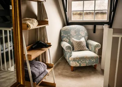 a small room with a chair and a mirror at Old Customs House in Harwich
