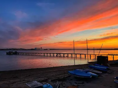 a group of boats sitting on the beach at a pier at Ten Admiralty Pier in Shotley Gate