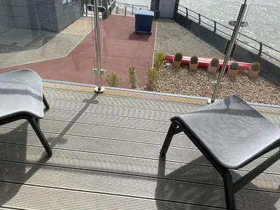 two chairs sitting on a deck near the water at Ten Admiralty Pier in Shotley Gate
