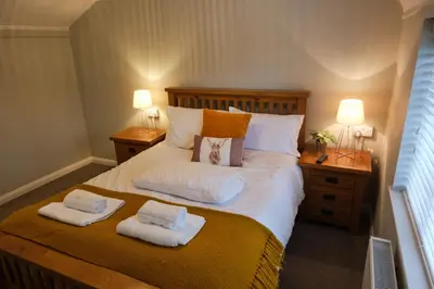 a bedroom with a large bed with two towels on it at The Granary Cottages