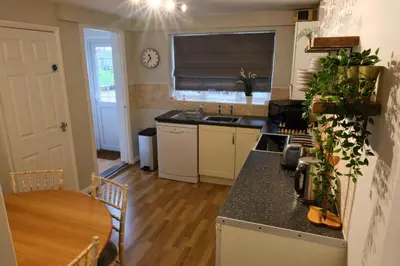 a kitchen with a table and a counter top at The Granary Cottages