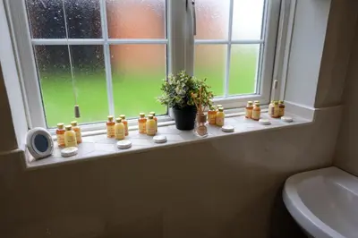 a bathroom window with a bunch of bottles on a window sill at The Granary Cottages