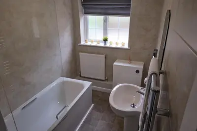 a bathroom with a tub and a toilet and a sink at The Granary Cottages