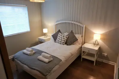 a small bedroom with a bed with two night stands at The Granary Cottages