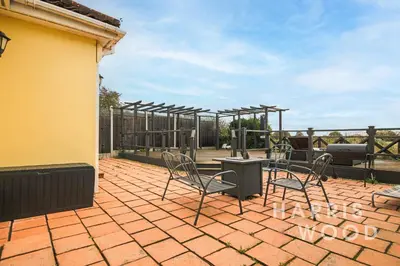 a patio with chairs and tables and a fence at Harvest Close, Marks Tey in Marks Tey