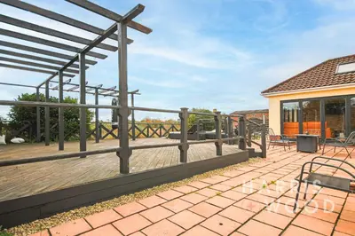 a patio with a fence and tables and chairs at Harvest Close, Marks Tey in Marks Tey