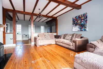 a living room with two couches and a wooden floor at Harvest Close, Marks Tey in Marks Tey