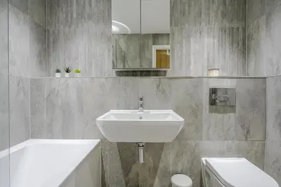 a bathroom with a sink and a tub and a toilet at Modern Apartment in Chelmsford City, Free WiFi & Free Parking - Dukes Apartment by Stays Accommodation - Long Stays Welcome in Chelmsford
