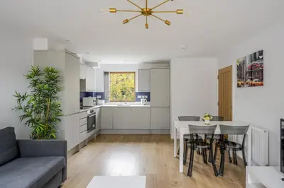 a kitchen and living room with a table and chairs at Modern Apartment in Chelmsford City, Free WiFi & Free Parking - Dukes Apartment by Stays Accommodation - Long Stays Welcome in Chelmsford